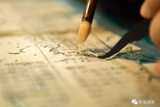 施文嵐在破洞的地方輕輕涂上自制的漿糊 施文嵐在破洞的地方輕輕涂上自制的漿糊